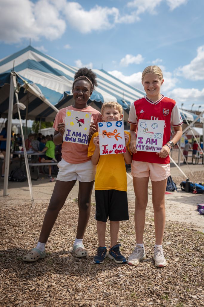 CampMirage95 kids holding up artwork they made at camp